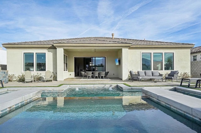 back of house featuring pool water feature, a swimming pool with hot tub, an outdoor living space, and a patio area