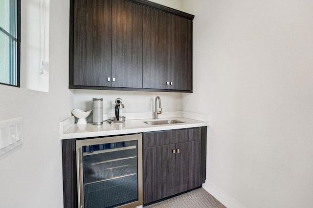 bar featuring sink, light tile patterned floors, wine cooler, and dark brown cabinetry