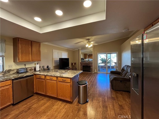 kitchen featuring kitchen peninsula, wood-type flooring, vaulted ceiling, dishwasher, and ceiling fan