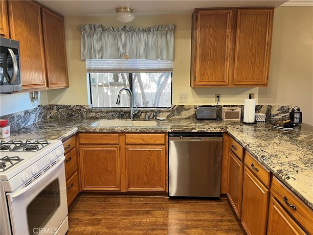 kitchen featuring sink, appliances with stainless steel finishes, dark hardwood / wood-style floors, and stone counters