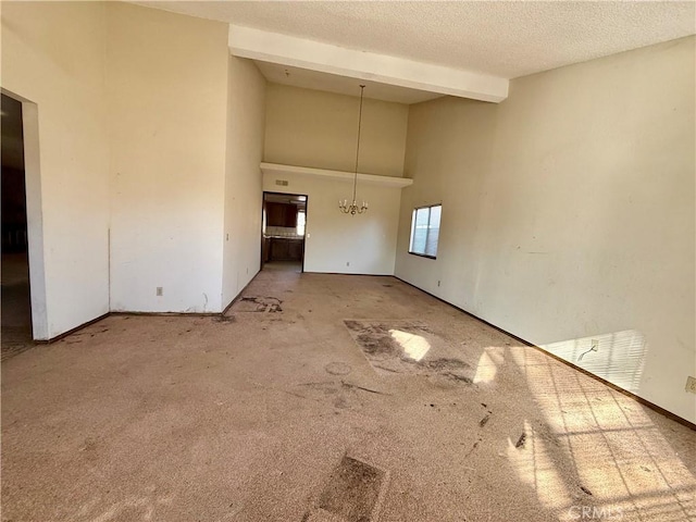 interior space featuring a textured ceiling, a towering ceiling, carpet floors, beamed ceiling, and an inviting chandelier