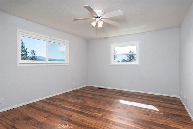 empty room with dark wood-type flooring and ceiling fan