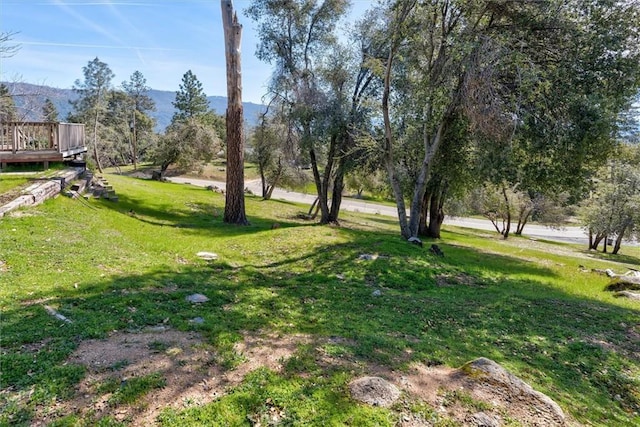 view of yard with a deck with mountain view