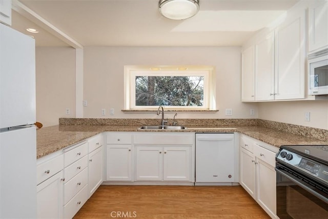 kitchen with white appliances, sink, and white cabinets