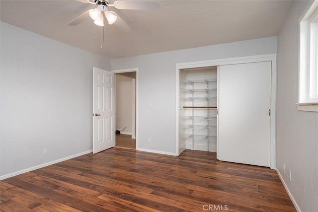 unfurnished bedroom featuring ceiling fan, dark hardwood / wood-style flooring, and a closet