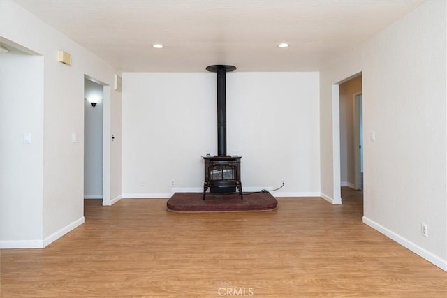 unfurnished living room featuring light hardwood / wood-style flooring and a wood stove