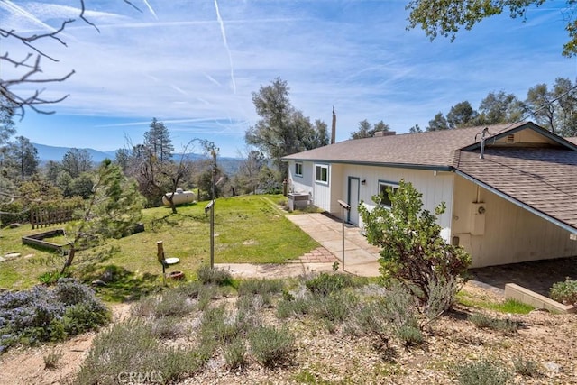 view of property exterior featuring a yard, a mountain view, and a patio