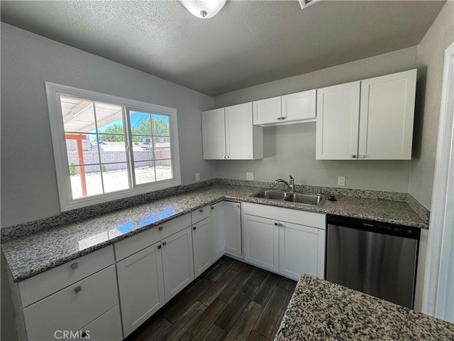 kitchen with dark wood-type flooring, sink, white cabinets, and stainless steel dishwasher