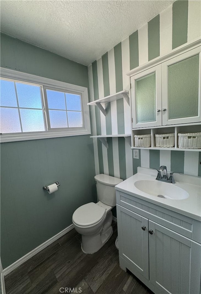 bathroom with vanity, toilet, hardwood / wood-style floors, and a textured ceiling