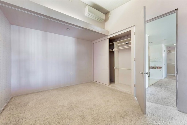 unfurnished bedroom with a closet, a wall mounted AC, and light carpet