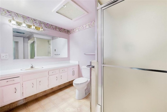 bathroom with vanity, a shower with shower door, and toilet