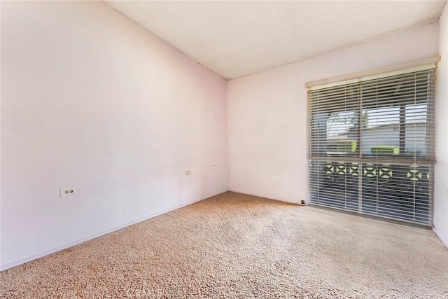 unfurnished room featuring vaulted ceiling and carpet