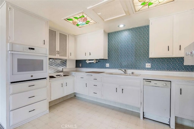 kitchen featuring white cabinets, white appliances, decorative backsplash, and sink