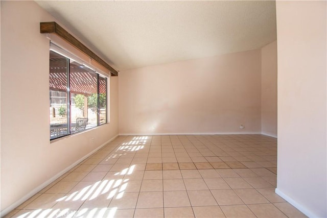 spare room with light tile patterned flooring and baseboards