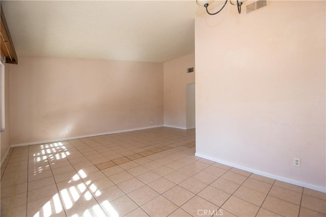 unfurnished room featuring baseboards, visible vents, and light tile patterned flooring