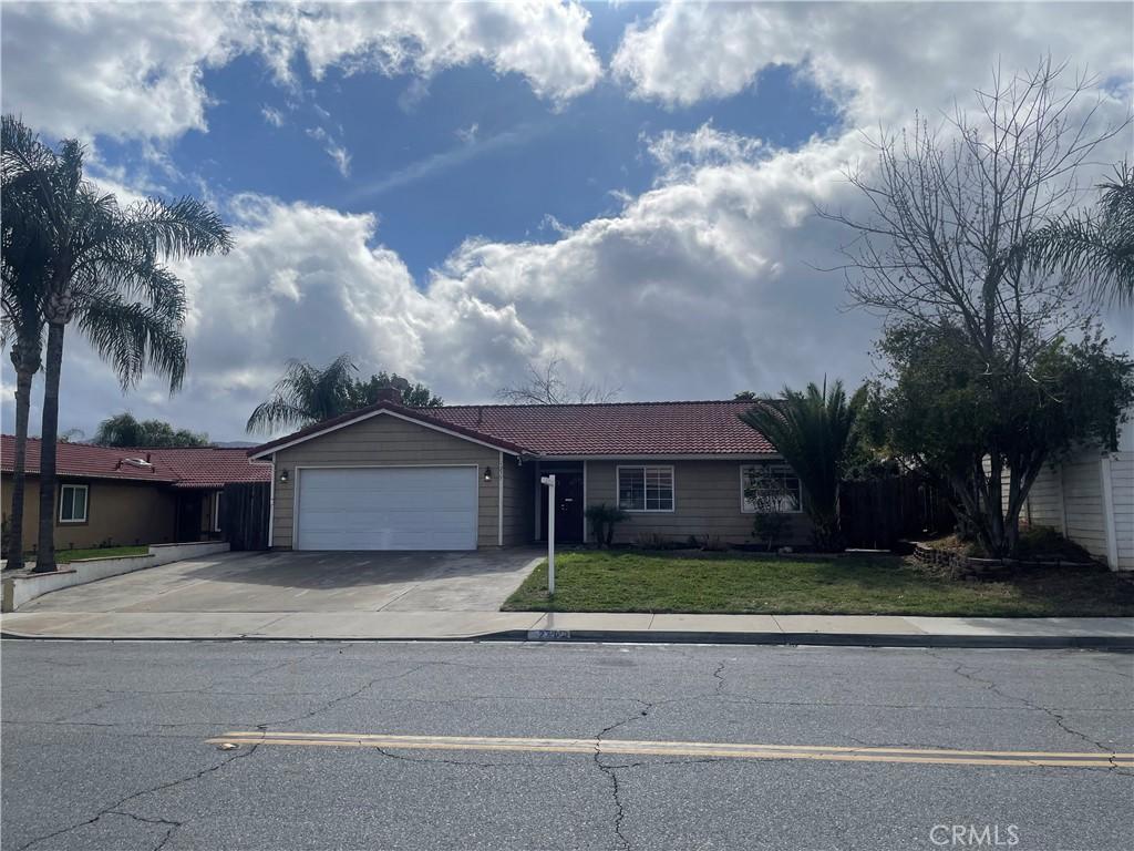 ranch-style home featuring a front yard, driveway, and an attached garage