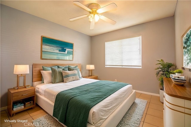 bedroom with light tile patterned floors, a ceiling fan, and baseboards