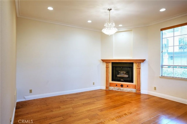 unfurnished living room featuring hardwood / wood-style flooring and ornamental molding