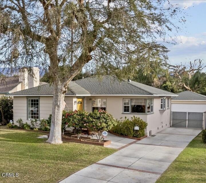 single story home featuring a garage and a front lawn