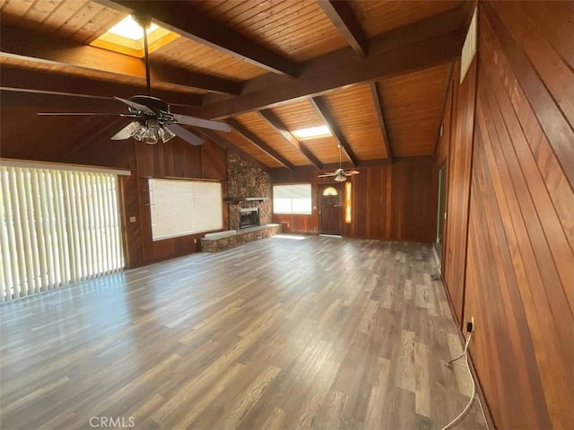 unfurnished living room featuring wooden ceiling, hardwood / wood-style floors, vaulted ceiling with skylight, and wood walls