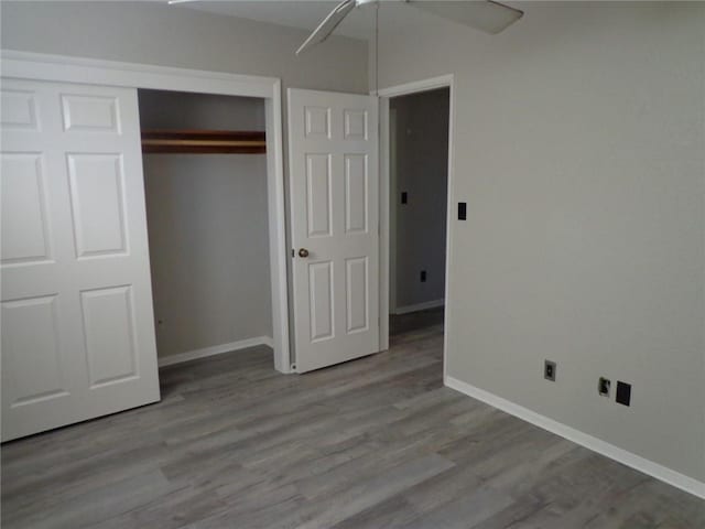 unfurnished bedroom with ceiling fan, light hardwood / wood-style floors, and a closet