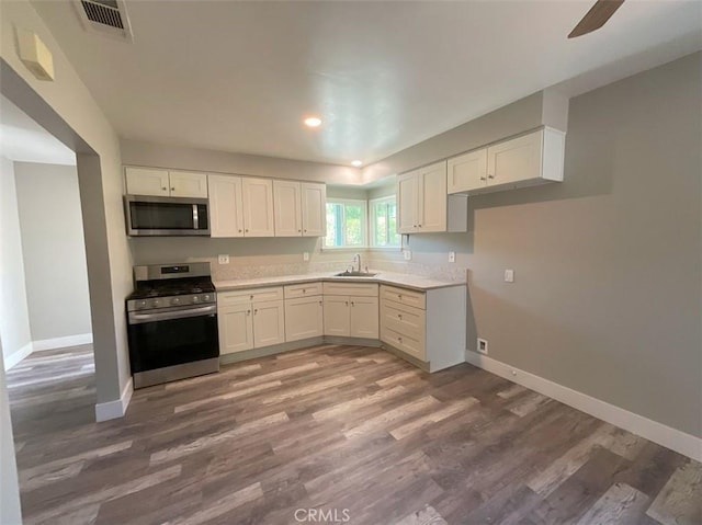 kitchen with sink, dark wood-type flooring, white cabinetry, and stainless steel appliances