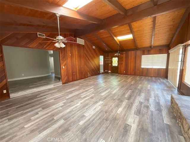 unfurnished living room with wooden ceiling, wood-type flooring, vaulted ceiling with beams, ceiling fan, and wood walls