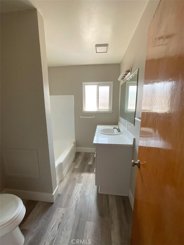 full bathroom featuring wood-type flooring, separate shower and tub, toilet, and vanity