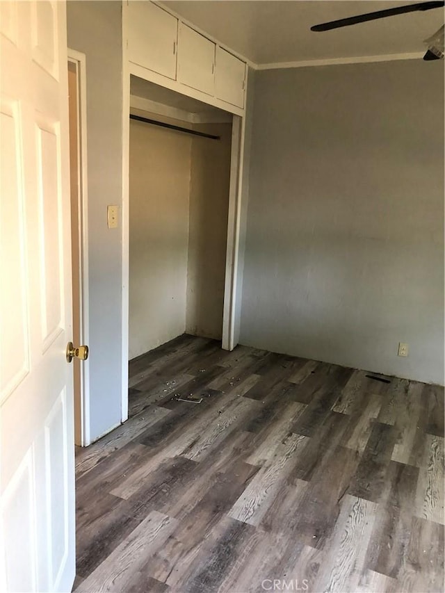 unfurnished bedroom featuring a closet and dark hardwood / wood-style flooring