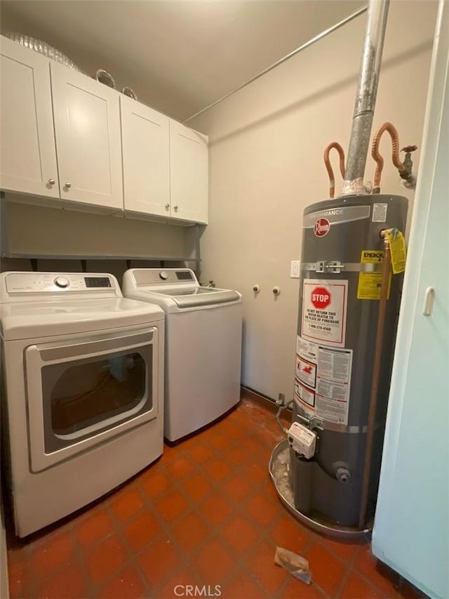 washroom featuring cabinets, dark tile patterned floors, washer and clothes dryer, and strapped water heater