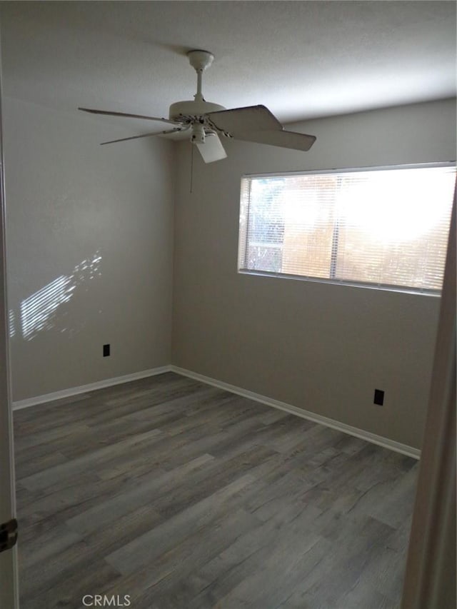 empty room featuring ceiling fan and dark hardwood / wood-style flooring