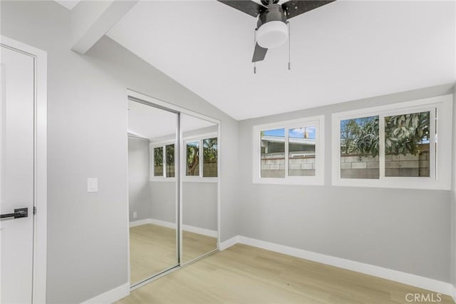 unfurnished bedroom with ceiling fan, vaulted ceiling, and hardwood / wood-style flooring