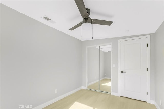 unfurnished bedroom featuring light hardwood / wood-style floors, a closet, and ceiling fan