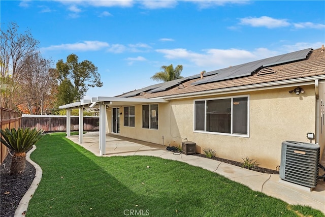 rear view of house featuring solar panels, central AC, a pergola, a yard, and a patio