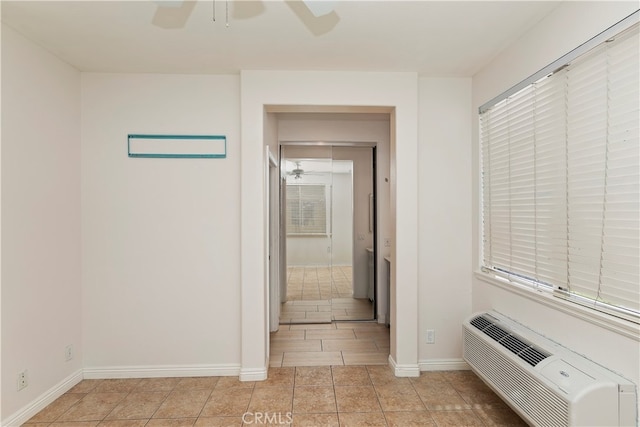 hall with light tile patterned floors and a wall mounted AC