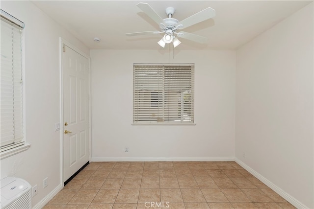 tiled spare room featuring ceiling fan