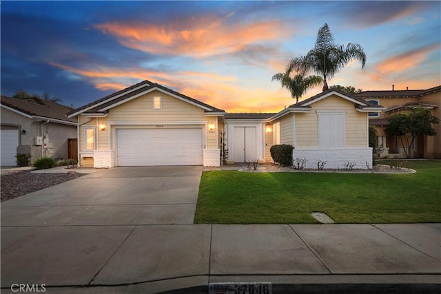 ranch-style house featuring a garage and a yard