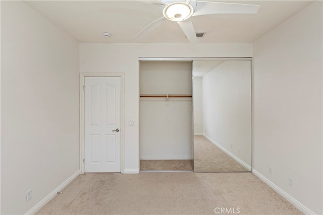 unfurnished bedroom with a closet, ceiling fan, and light carpet