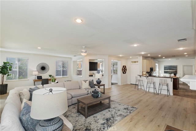 living room featuring ceiling fan and light hardwood / wood-style floors