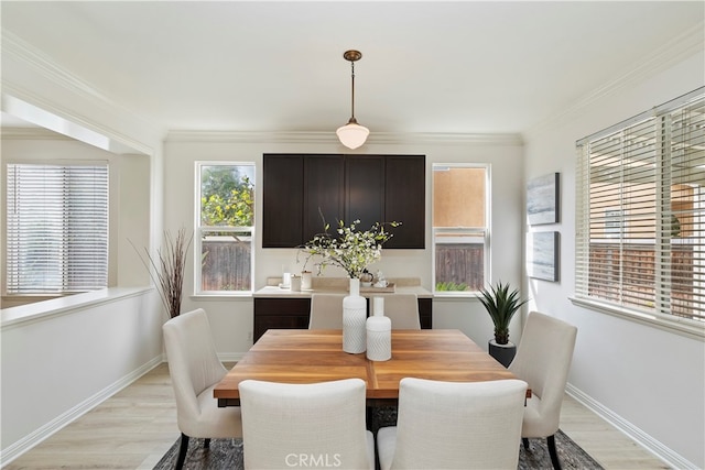 dining room featuring light hardwood / wood-style flooring and crown molding