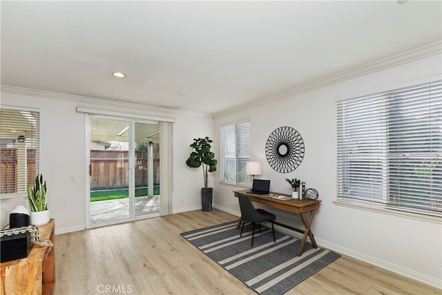 office area with light hardwood / wood-style floors and ornamental molding