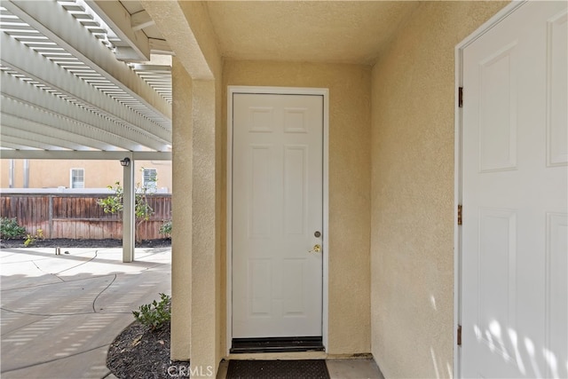 entrance to property featuring a patio area and a pergola