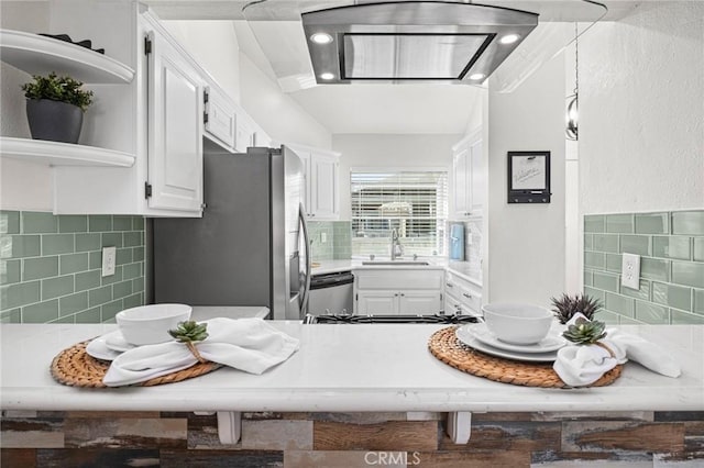 kitchen with white cabinets, appliances with stainless steel finishes, and decorative backsplash