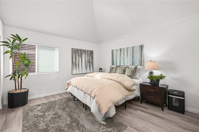 bedroom with high vaulted ceiling and light hardwood / wood-style flooring