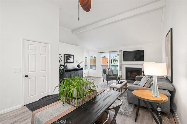 living room with light hardwood / wood-style flooring, beamed ceiling, high vaulted ceiling, and ceiling fan