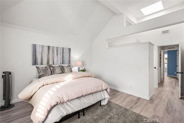 bedroom featuring light hardwood / wood-style flooring and lofted ceiling with skylight