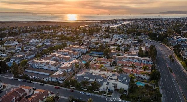 aerial view at dusk featuring a water view