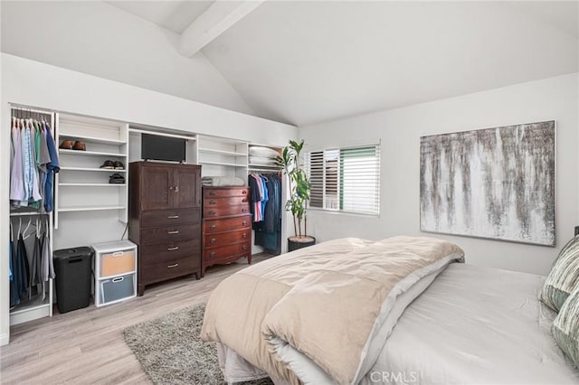 bedroom featuring a closet, lofted ceiling with beams, and light hardwood / wood-style flooring