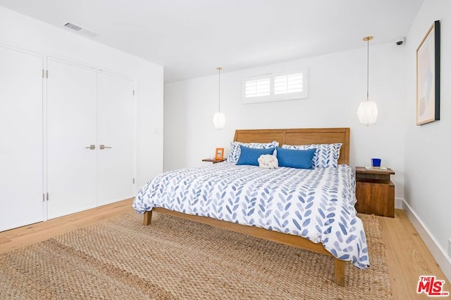 bedroom featuring hardwood / wood-style floors and a closet