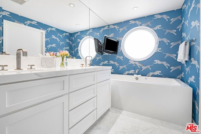 bathroom with vanity and a tub